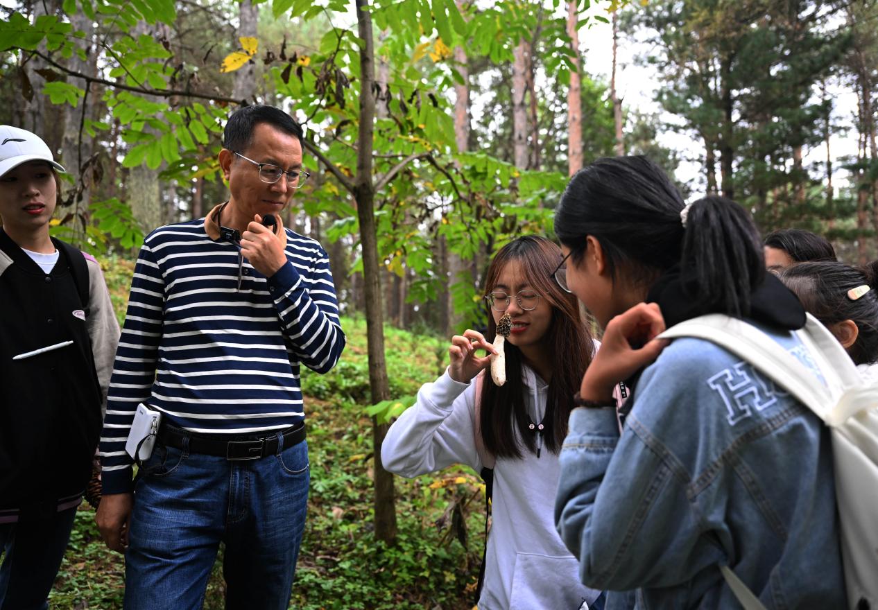 王占斌老師給同學(xué)們講解辨識(shí)蘑菇。（學(xué)校供圖）.jpg