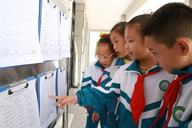 甘州區(qū)北街小學孩子在圍觀公示出的作業(yè)清單（張儒泰攝）.JPG