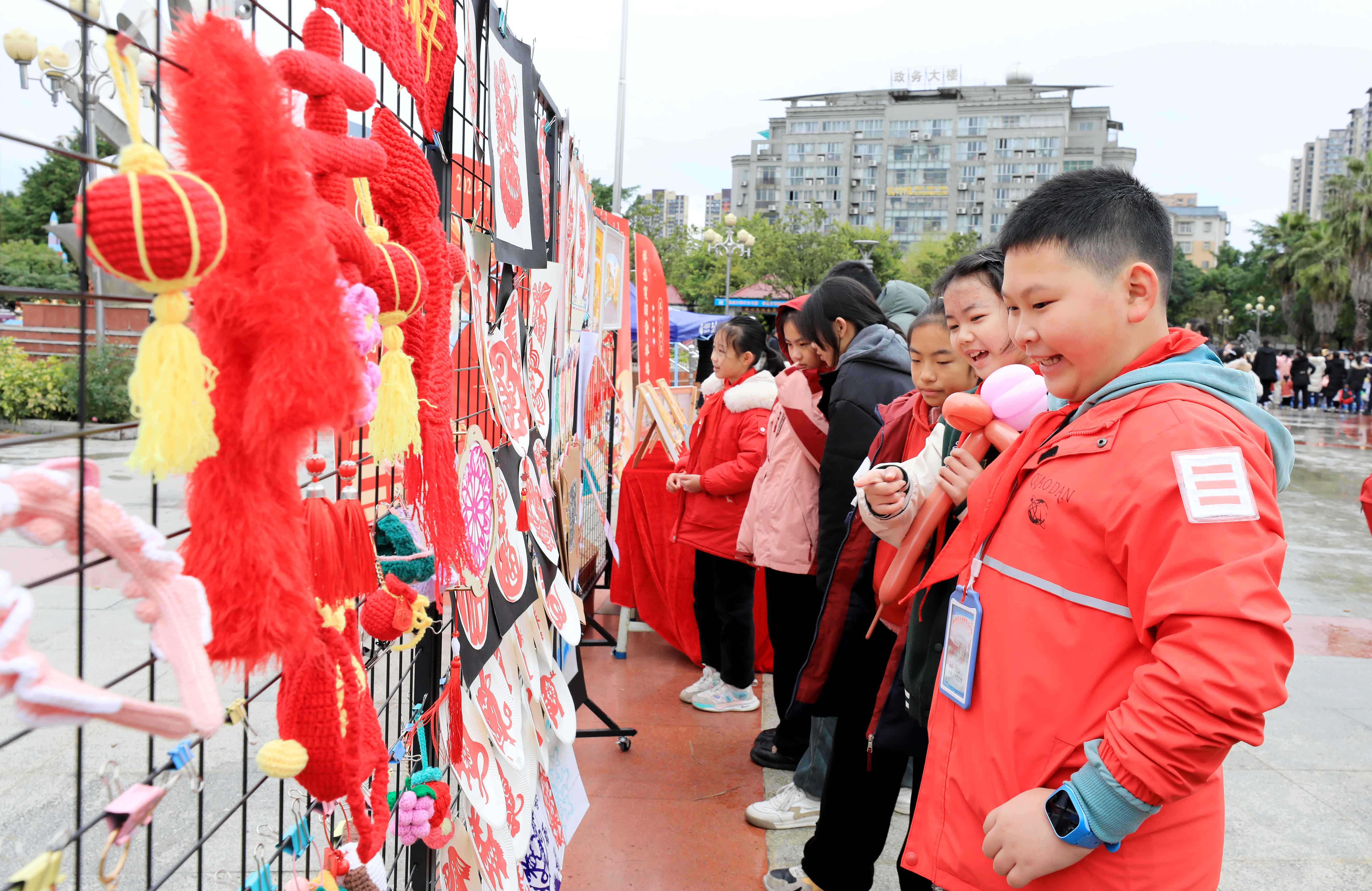 圖7：1月20日，在廣西柳州市融安縣長(zhǎng)安廣場(chǎng)，學(xué)生在非遺集市上選購(gòu)作品。（譚凱興 攝）.JPG