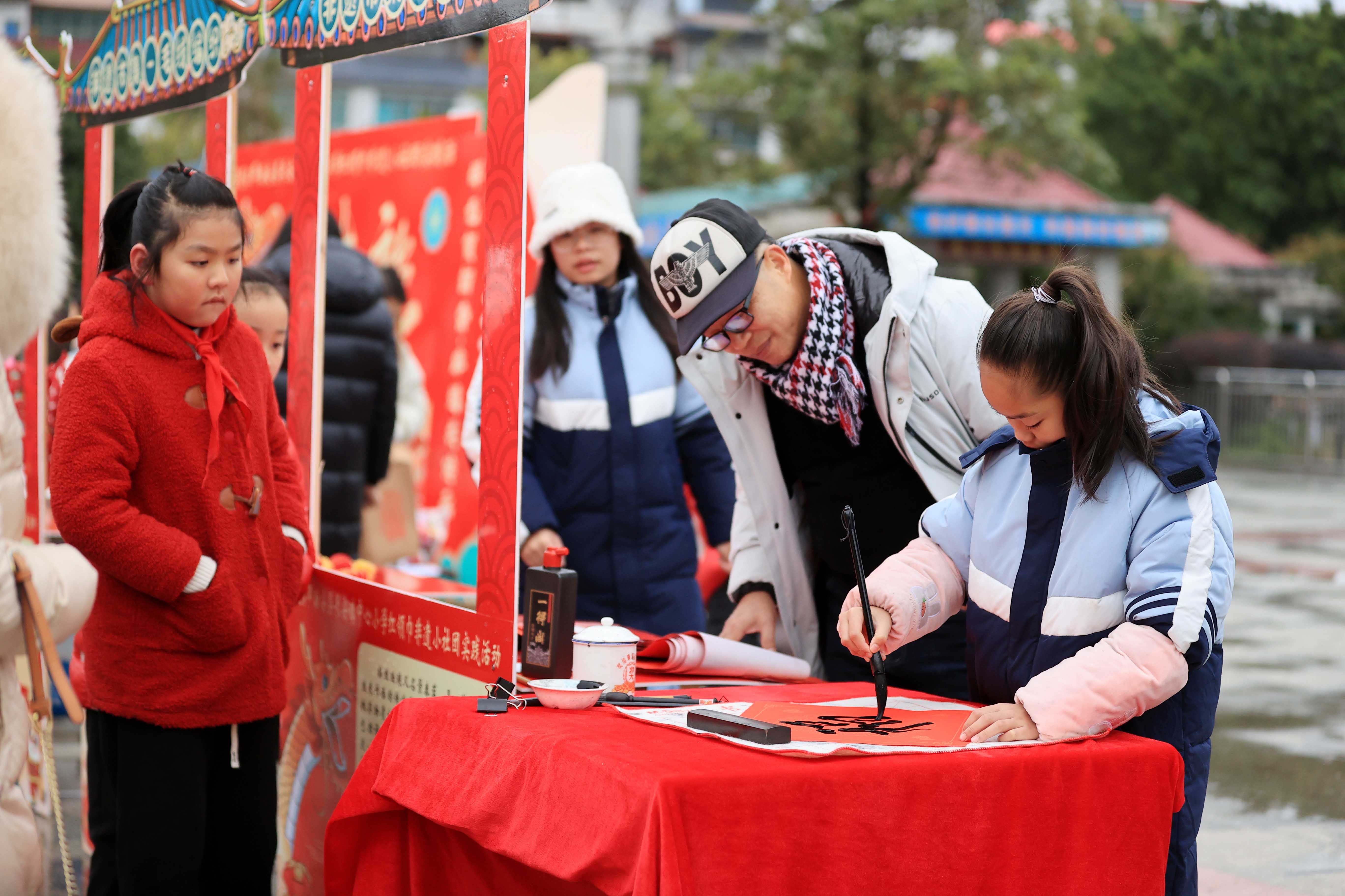 圖10：1月20日，在廣西柳州市融安縣長(zhǎng)安廣場(chǎng)，一名小學(xué)生在書(shū)寫(xiě)福字，準(zhǔn)備贈(zèng)送市民。（譚凱興 攝）.JPG