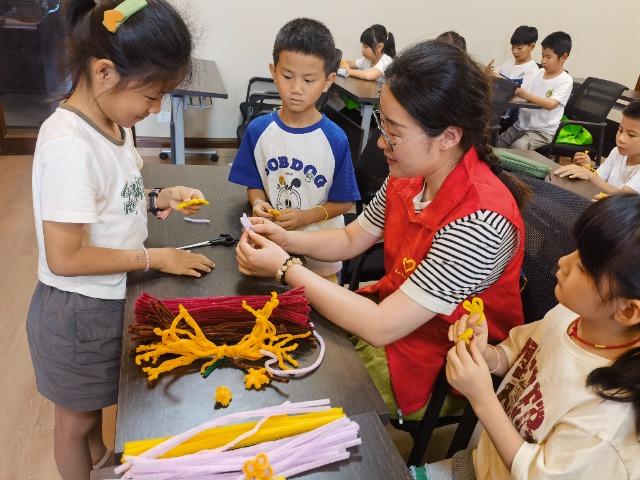 7月12日，在泰州市海陵區(qū)城東街道林湖社區(qū)，泰州市大浦小學“綠葉”暑期公益班的老師正在教孩子們一起做手工2（拍攝者：泰州市大浦中心小學  陳惠婷）.jpg